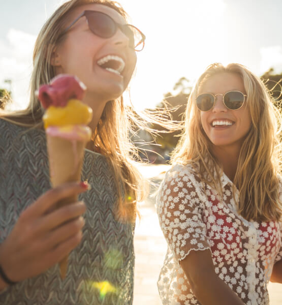 Two women with ice cream laughing