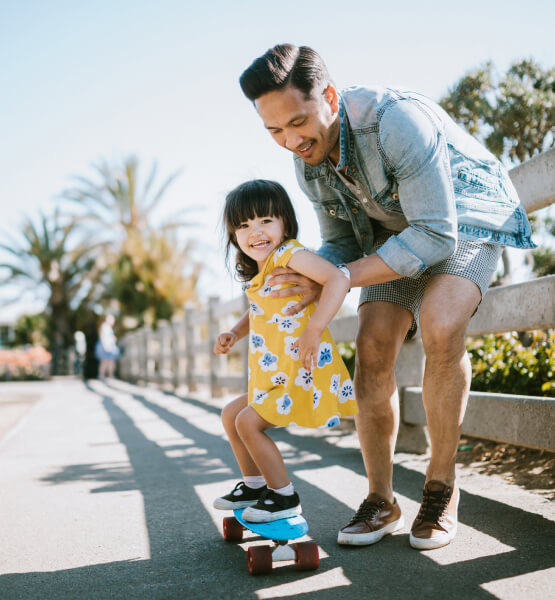 Father helping daughter skateboard