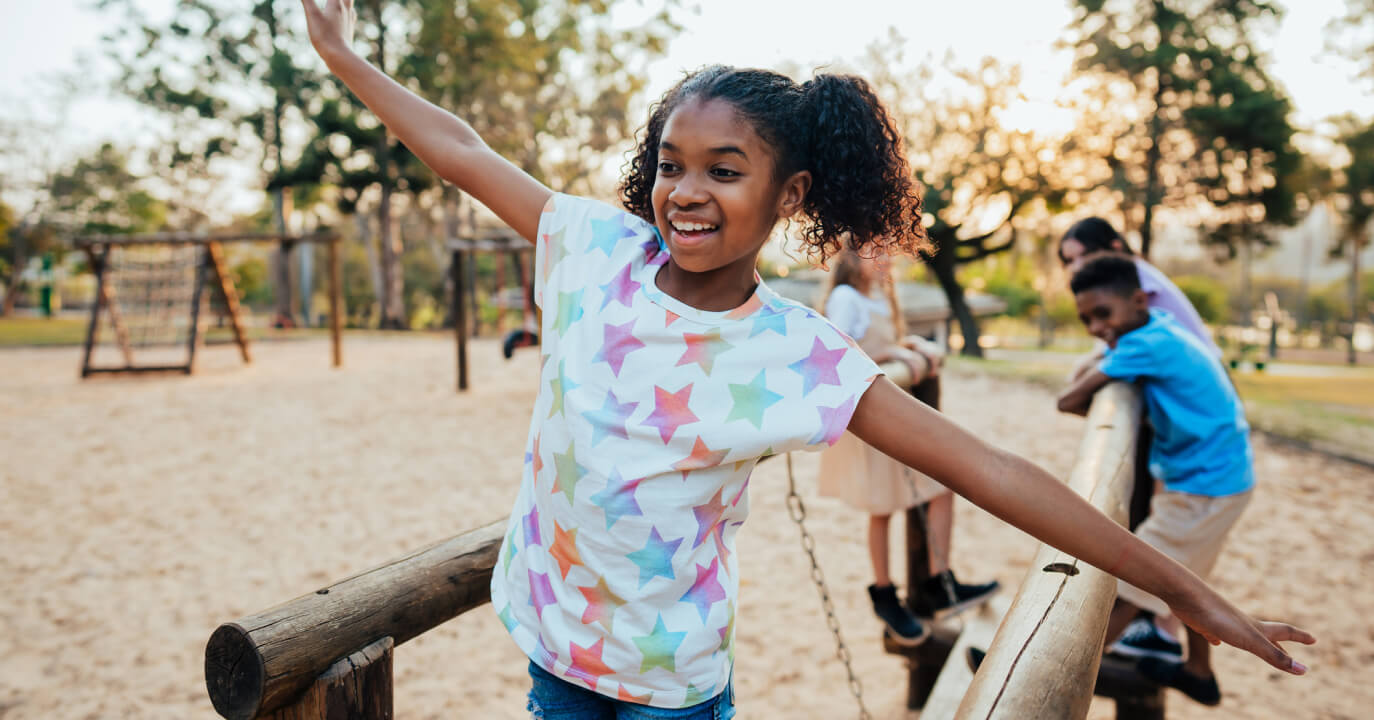 A young girl playing in a park with friends