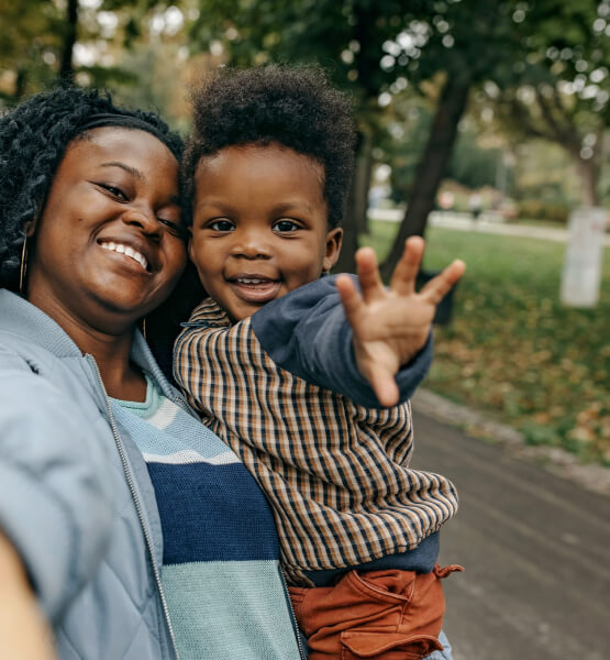 Mother holding her son outside smiling