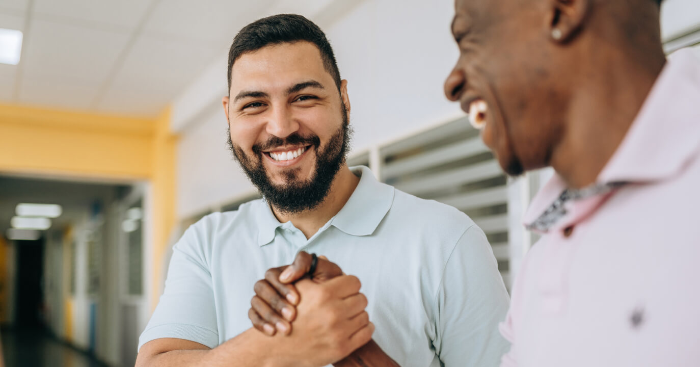 Two men holding hands and smiling