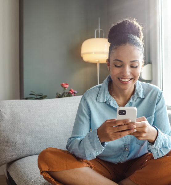 Woman using mobile phone in living room