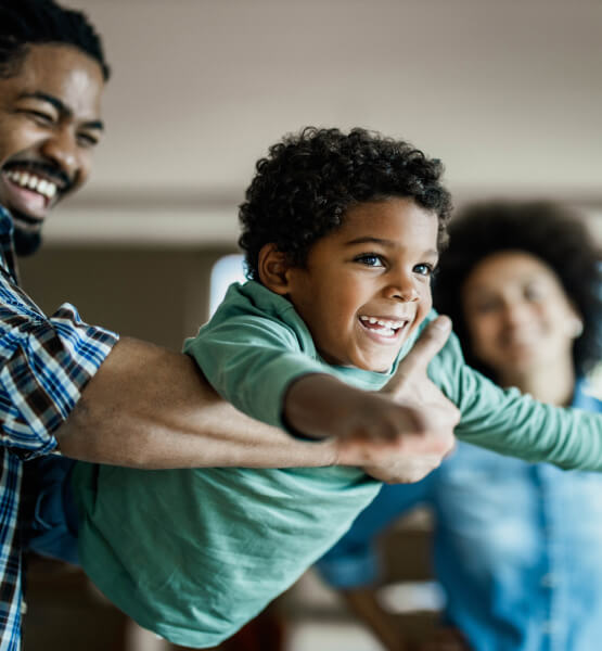 Father and son laughing together while the father holds his son