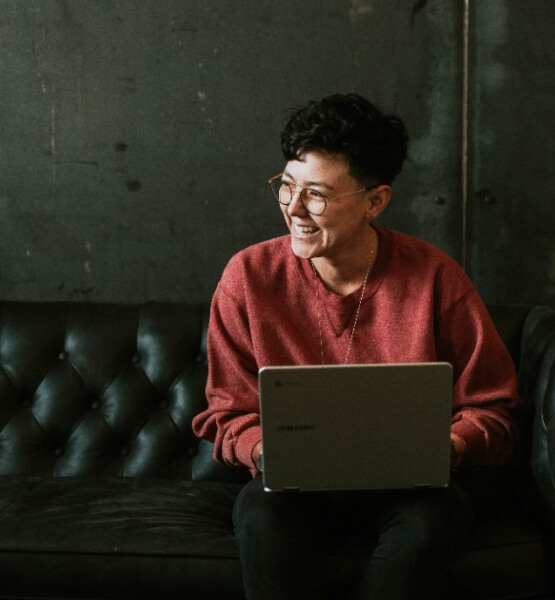 Woman on laptop smiling while working in an industrial office space